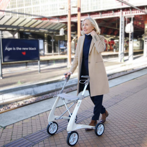 Rollator Carbo Ultralight blanc avec femme en gare